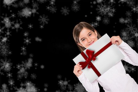 simsearch:400-07834588,k - Cute little girl showing card against red christmas ribbon Fotografie stock - Microstock e Abbonamento, Codice: 400-07835352