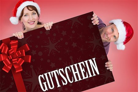 simsearch:400-07834588,k - Couple both wearing santa hats against gift card with festive bow Fotografie stock - Microstock e Abbonamento, Codice: 400-07835372