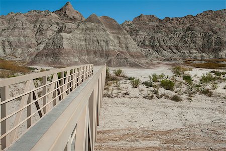 A hiking trail crosses a narrow bridge over a flash flood area in the Badlands of South Dakota. Stock Photo - Budget Royalty-Free & Subscription, Code: 400-07836047