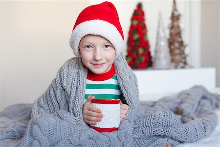 cute smiling boy sitting cozy in the blanket at home, holding cup of hot cocoa at christmas time Stock Photo - Budget Royalty-Free & Subscription, Code: 400-07836391