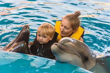 Two-year boy and mum float with dolphins in pool Stock Photo - Budget Royalty-Free & Subscription, Code: 400-07839829