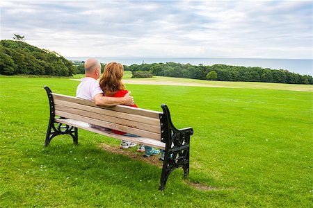 Rear view of middle age couple sitting on a bench looking at the sea Stock Photo - Budget Royalty-Free & Subscription, Code: 400-07831385
