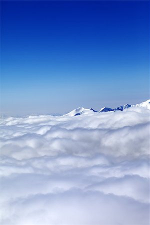 Mountains under clouds and clear blue sky. Caucasus Mountains, Georgia, Gudauri. View from ski slope. Photographie de stock - Aubaine LD & Abonnement, Code: 400-07833347