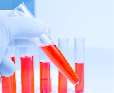 hand in glove is holding test tube with red liquid in laboratory on white background Stock Photo - Budget Royalty-Free & Subscription, Code: 400-07840658