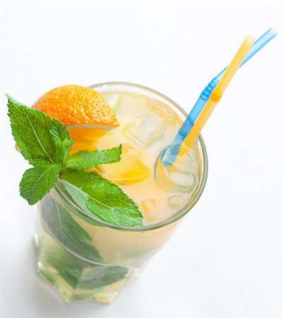 Glass of fresh made non-alcoholic drink citrus lemonade with ice cubes, mint , orange segment and straws. Top view on white background Stock Photo - Budget Royalty-Free & Subscription, Code: 400-07894297