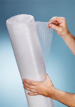Man holding a roll of plastic bubble wrap. Stockbilder - Microstock & Abonnement, Bildnummer: 400-07894440