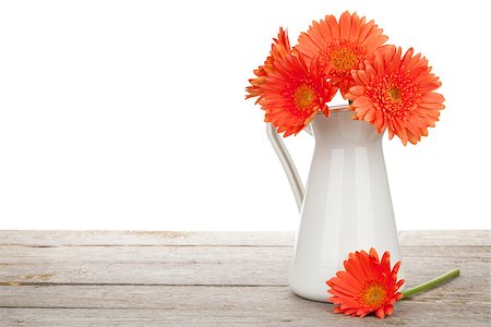 simsearch:400-07179442,k - Orange gerbera flowers in pitcher on wooden table. Isolated on white background Stock Photo - Budget Royalty-Free & Subscription, Code: 400-07894859