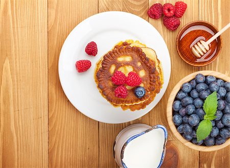 simsearch:400-09019412,k - Pancakes with raspberry, blueberry, milk and honey syrup. On wooden table with copy space Foto de stock - Super Valor sin royalties y Suscripción, Código: 400-07894924