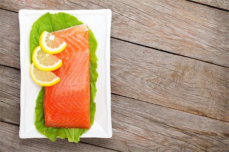 simsearch:400-08187570,k - Fresh salmon fish with lemon and salad leaves on wooden table with copy space Stockbilder - Microstock & Abonnement, Bildnummer: 400-07894920