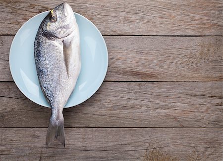 Fresh dorado fish on wooden table with copy space Stockbilder - Microstock & Abonnement, Bildnummer: 400-07894934