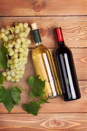 simsearch:400-08110621,k - Red and white wine bottles and bunch of grapes on wooden table Stock Photo - Budget Royalty-Free & Subscription, Code: 400-07894953