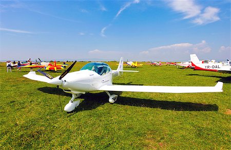 simsearch:400-04493361,k - Brasov, Romania - August 12, 2010: White airplane on a green grass field preparing to take off for a flight show Photographie de stock - Aubaine LD & Abonnement, Code: 400-07895068