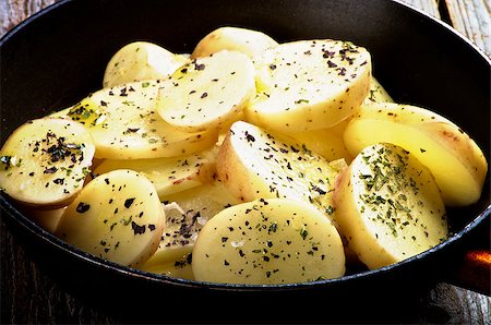 simsearch:400-06485810,k - Wedges of Raw Potato with Basil, Salt and Olive Oil in Black Fry Pan closeup Fotografie stock - Microstock e Abbonamento, Codice: 400-07895273
