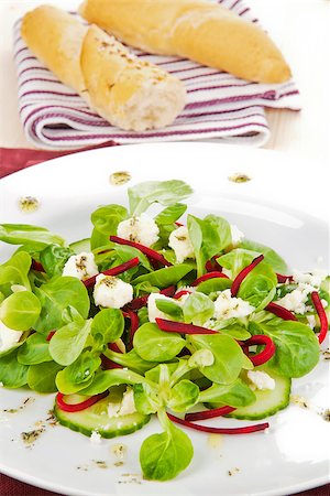 simsearch:400-04293911,k - Fresh salad leaves with cucumber pieces, beet and goat cheese with white bread in background. Stock Photo - Budget Royalty-Free & Subscription, Code: 400-07895347