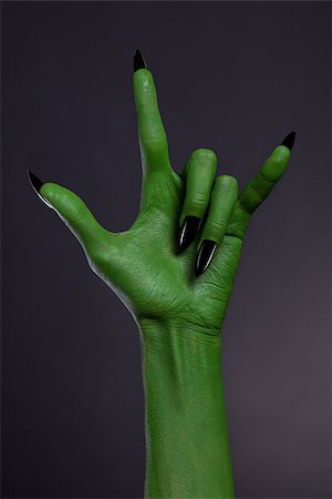 Green hand with black nails showing heavy metal gesture, studio shot on black background Stock Photo - Budget Royalty-Free & Subscription, Code: 400-07895476