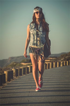 Beautiful Young woman walking and holding a skateboard Foto de stock - Super Valor sin royalties y Suscripción, Código: 400-07896624