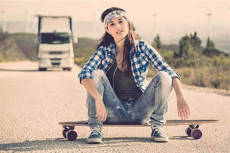 Beautiful young woman sitting over a skateboard Stock Photo - Budget Royalty-Free & Subscription, Code: 400-07896621