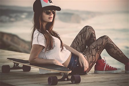 Beautiful and fashion young woman posing with a skateboard Foto de stock - Super Valor sin royalties y Suscripción, Código: 400-07896636