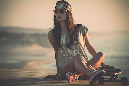 Beautiful young woman sitting over a skateboard Foto de stock - Super Valor sin royalties y Suscripción, Código: 400-07896631