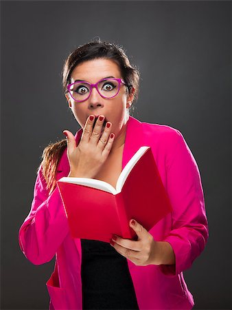 Middle aged woman with a astonished expression and holding a red book Stock Photo - Budget Royalty-Free & Subscription, Code: 400-07897711