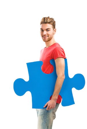people holding puzzle pieces - Good looking young man holding a blue puzzle piece, isolated on a white background Stock Photo - Budget Royalty-Free & Subscription, Code: 400-07897741