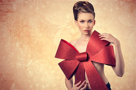 simsearch:400-07218439,k - christmas portrait of beautiful blonde female posing with elegant hair-style and big glitter red bow on her naked breast. Foto de stock - Super Valor sin royalties y Suscripción, Código: 400-07897898