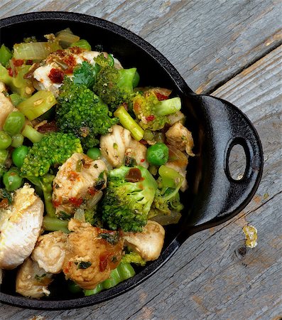 simsearch:400-07481067,k - Homemade Chicken Stew with Broccoli, Bell Pepper and Green Pea in Black Saucepan closeup on Rustic Wooden background. Top View Stock Photo - Budget Royalty-Free & Subscription, Code: 400-07899029