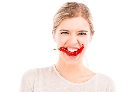 simsearch:400-04575822,k - Beautiful girl biting a red chilli pepper, isolated over a white background Photographie de stock - Aubaine LD & Abonnement, Code: 400-07899698