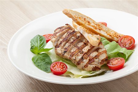 Gourmet delicious caesar salad with grilled beef meat fillet, romaine lettuce, cherry tomatoes,  cheese croutons and basil served in white plate Stock Photo - Budget Royalty-Free & Subscription, Code: 400-07899769