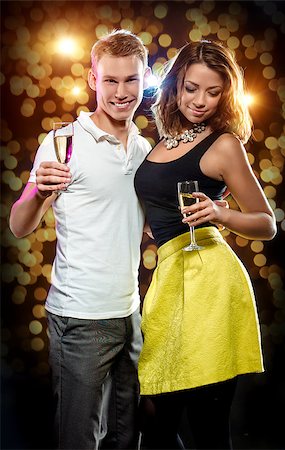 Young attractive couple with glasses of sparkling champagne over abstract golden background Stock Photo - Budget Royalty-Free & Subscription, Code: 400-07891697