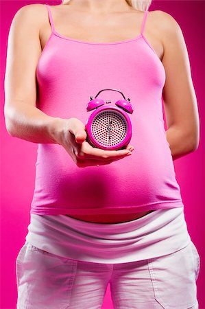 simsearch:400-07892376,k - Pregnant woman holding alarm clock Foto de stock - Royalty-Free Super Valor e Assinatura, Número: 400-07892275