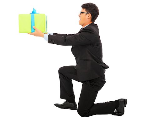 young Business man holding a gift box and kneel. isolated on white background Stock Photo - Budget Royalty-Free & Subscription, Code: 400-07892495