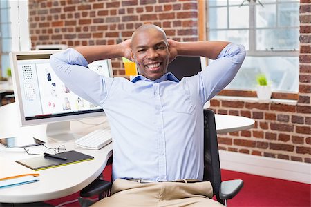 Portrait of young businessman sitting with hands behind head at office desk Stock Photo - Budget Royalty-Free & Subscription, Code: 400-07900328