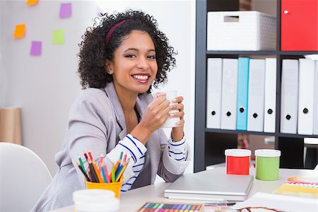 Portrait of smiling female interior designer with coffee cup sitting at office desk Photographie de stock - Aubaine LD & Abonnement, Code: 400-07900388