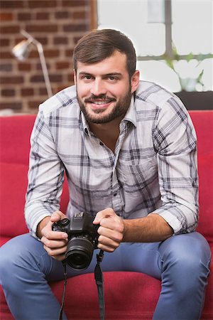 simsearch:400-07466593,k - Portrait of casual photo editor holding camera in the office Stock Photo - Budget Royalty-Free & Subscription, Code: 400-07900498