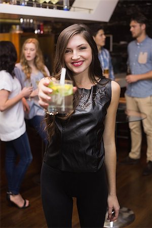 simsearch:6122-08212398,k - Pretty brunette holding a cocktail at the bar Stock Photo - Budget Royalty-Free & Subscription, Code: 400-07900620