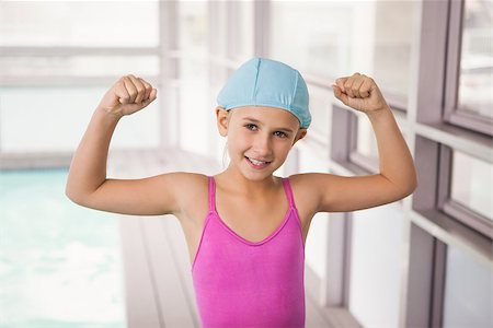 swimming kid in swimming cap photos - Cute little girl flexing her arms at the leisure center Stock Photo - Budget Royalty-Free & Subscription, Code: 400-07901036