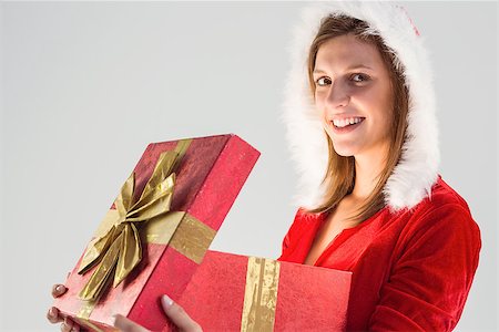 simsearch:400-07902186,k - Smiling girl opening a gift and looking at the camera on gray background Foto de stock - Super Valor sin royalties y Suscripción, Código: 400-07901514