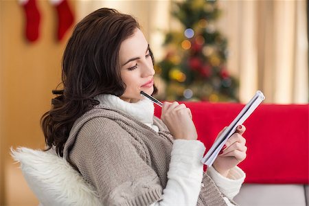 simsearch:400-07931092,k - Brunette lying on the couch thinking about her christmas list at home in the living room Foto de stock - Super Valor sin royalties y Suscripción, Código: 400-07901628