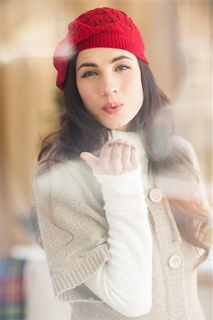 Pretty brunette blowing a kiss at home in the living room Stock Photo - Budget Royalty-Free & Subscription, Code: 400-07901653