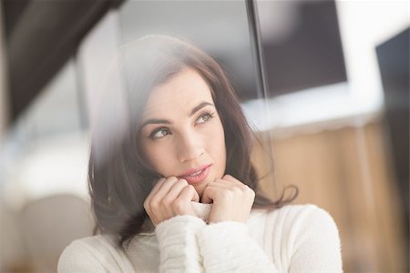 simsearch:6110-09101637,k - Brunette in white wool jumper thinking at home in the living room Stockbilder - Microstock & Abonnement, Bildnummer: 400-07901665