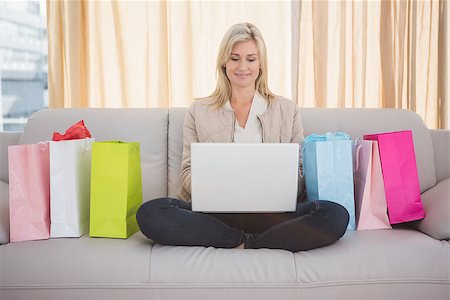 simsearch:400-07474252,k - Pretty blonde shopping online with laptop at home in the living room Stock Photo - Budget Royalty-Free & Subscription, Code: 400-07901748