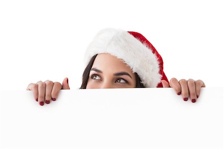 santa christmas hat women - Pretty brunette in santa hat showing white poster on white background Stock Photo - Budget Royalty-Free & Subscription, Code: 400-07902044