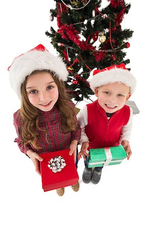 simsearch:400-07753751,k - Festive little siblings smiling at camera holding gifts on white background Stock Photo - Budget Royalty-Free & Subscription, Code: 400-07902162