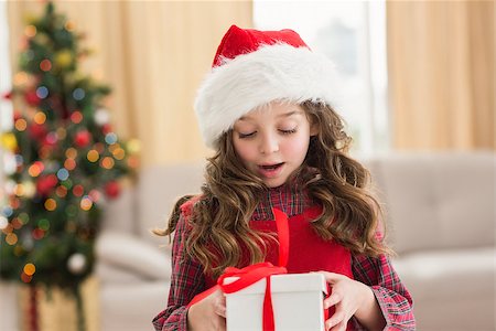 simsearch:400-07902186,k - Festive little girl opening a gift at home in the living room Foto de stock - Super Valor sin royalties y Suscripción, Código: 400-07902189