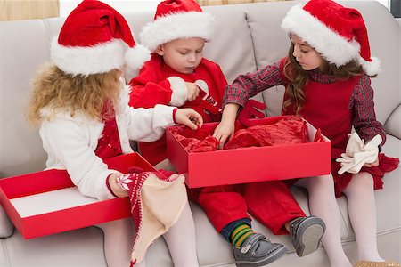 simsearch:400-07902186,k - Festive little siblings opening a gift at home in the living room Foto de stock - Super Valor sin royalties y Suscripción, Código: 400-07902195