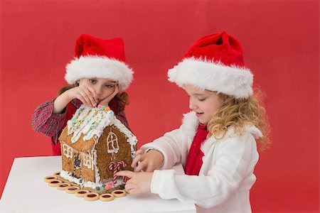 simsearch:400-05352235,k - Festive little girls making a gingerbread house on red background Photographie de stock - Aubaine LD & Abonnement, Code: 400-07902199