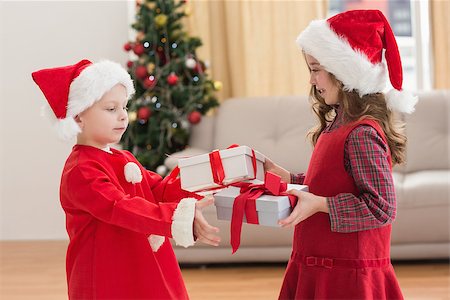 simsearch:400-07753751,k - Festive little siblings holding gifts at home in the living room Stock Photo - Budget Royalty-Free & Subscription, Code: 400-07902191