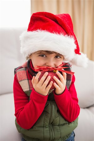 simsearch:400-07902186,k - Festive little boy smiling at camera with bauble at home in the living room Foto de stock - Super Valor sin royalties y Suscripción, Código: 400-07902215