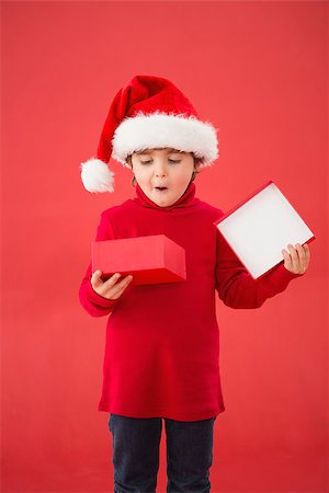 simsearch:400-07753751,k - Festive little boy opening a gift on red background Stock Photo - Budget Royalty-Free & Subscription, Code: 400-07902227